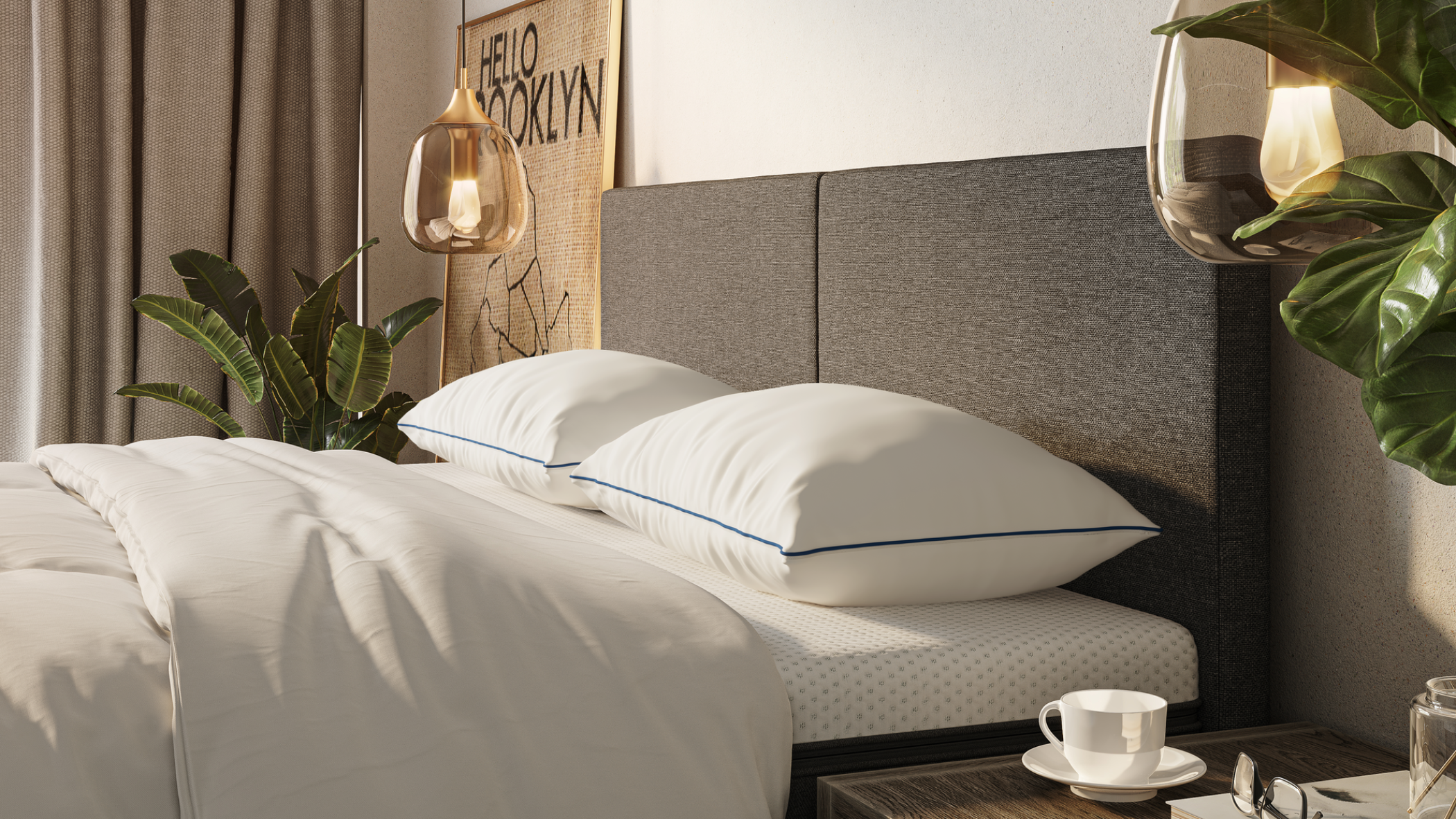 Un lit confortable avec une literie blanche et deux grands oreillers est posé à côté d'une table de nuit contenant une tasse et une soucoupe. Des plantes, des lampes suspendues et un imprimé encadré "Hello Brooklyn" décorent la chambre à coucher moderne.