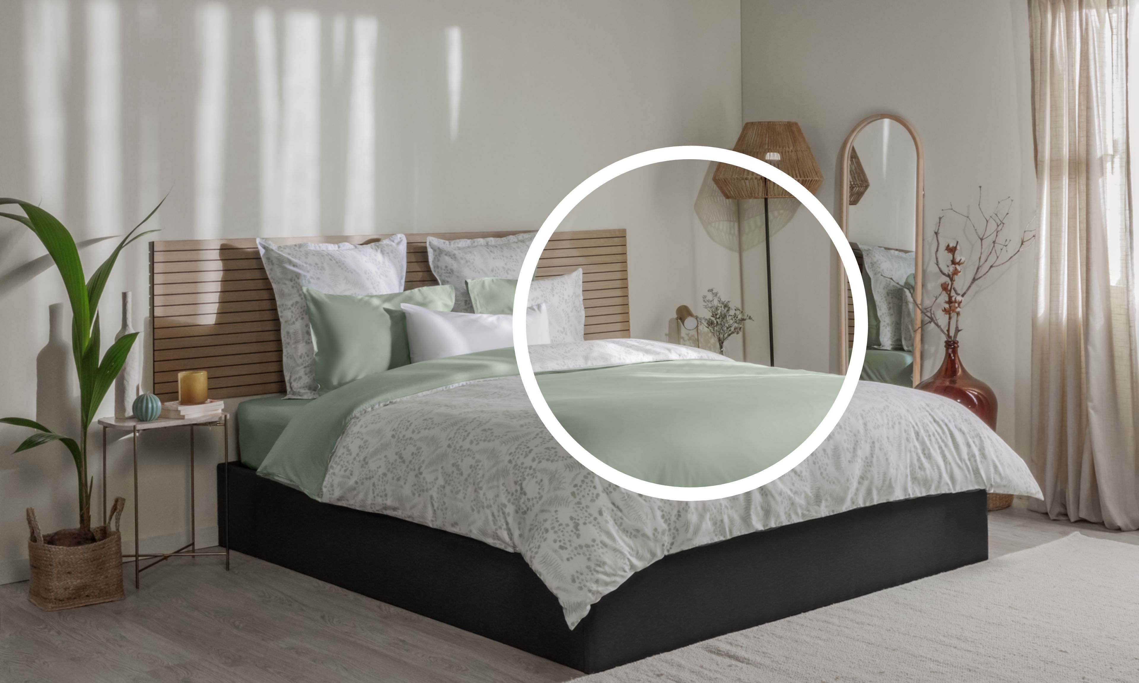 Letto ordinato con biancheria verde chiaro e bianca, testiera in legno e decorazioni naturali ai lati.