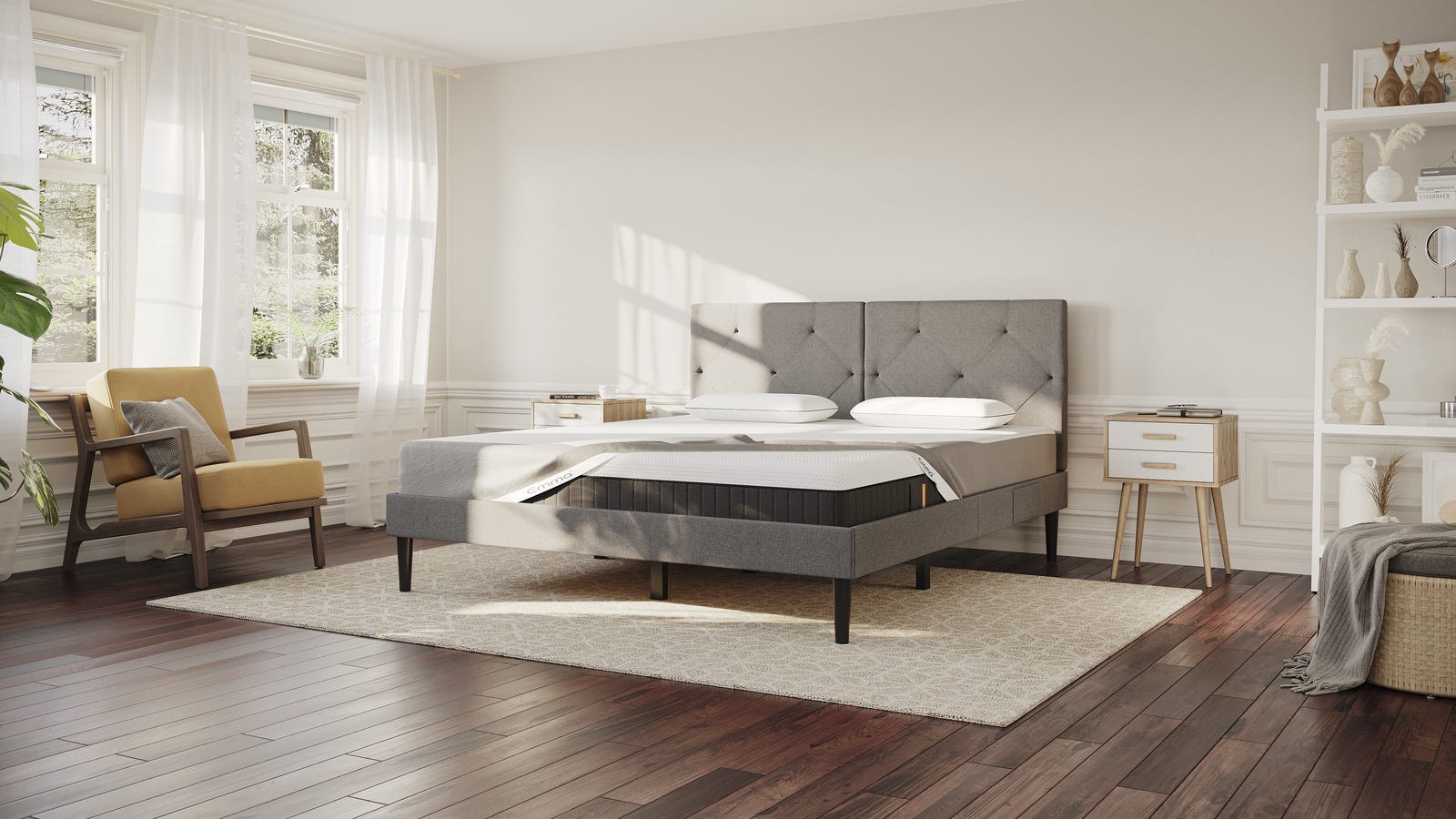Boxspringbett-Set mit Topper, Matratze und Kissen in hellem Schlafzimmer mit Tageslicht und Sessel.