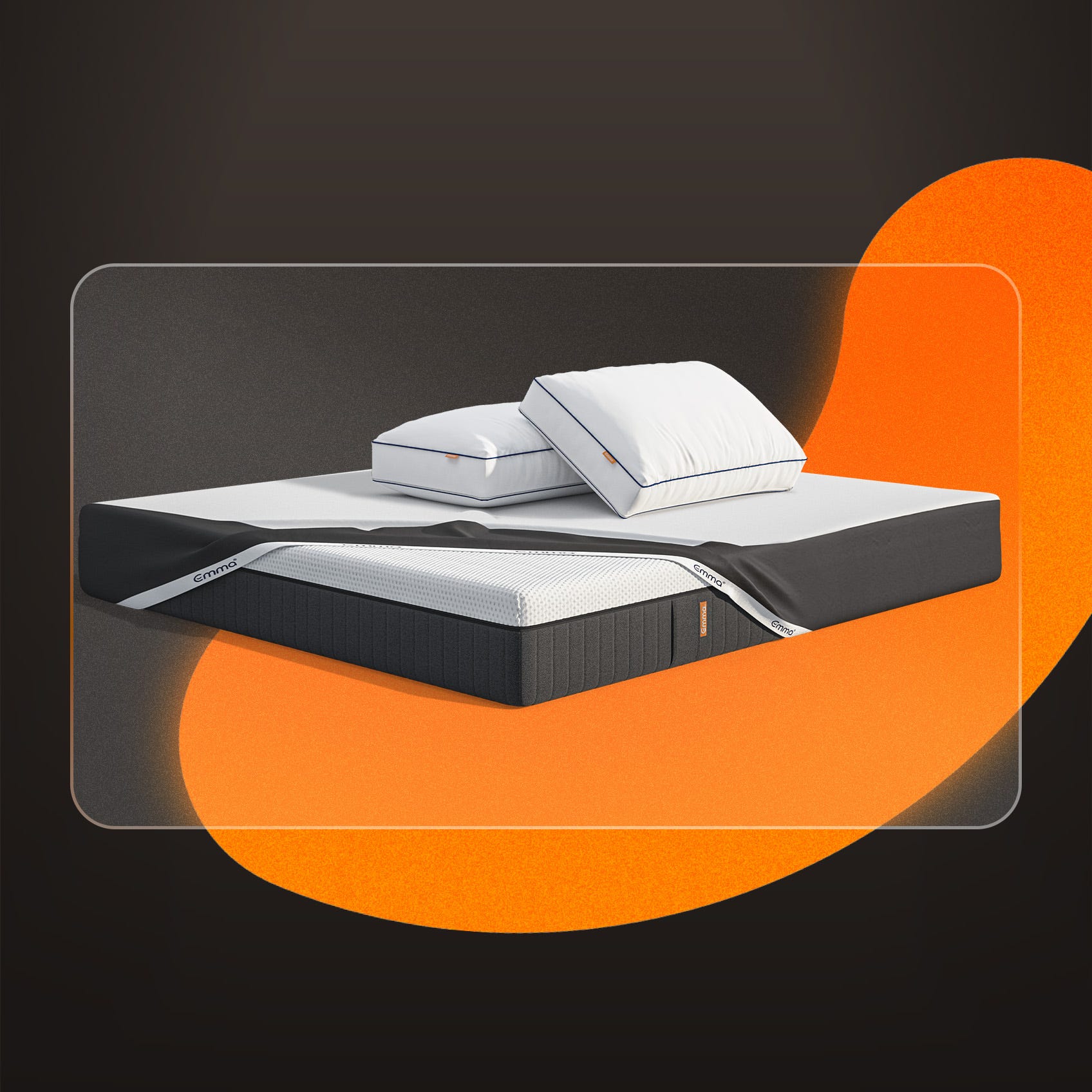 A mattress, pillows and protector on a dark background.