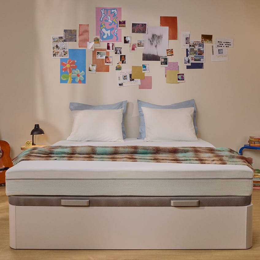 White Emma mattress on an upholstered bed.