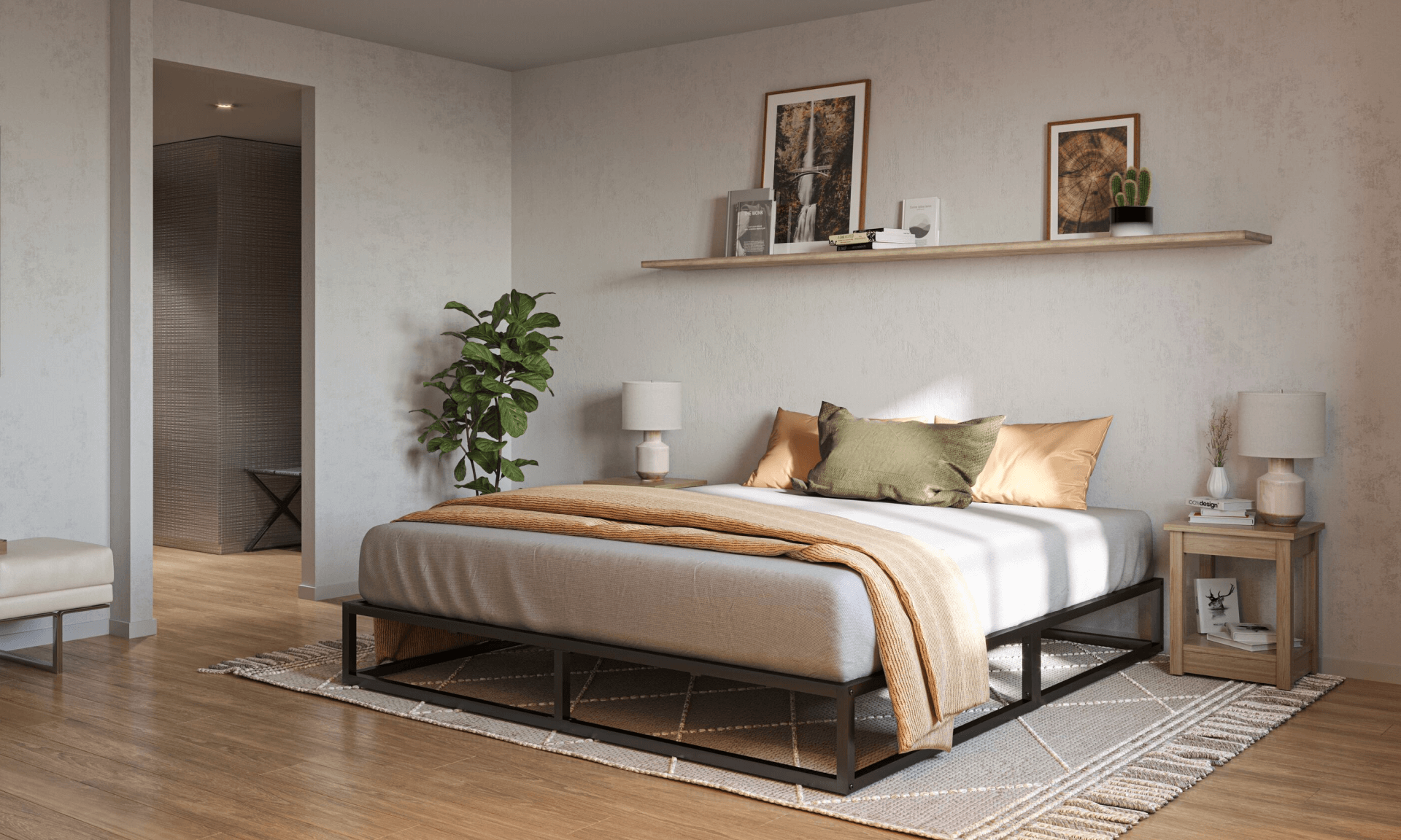 Moderne slaapkamer met lichtgrijs gestoffeerd bedframe en beige deken; bed is voorzien van groene en beige kussens, geflankeerd door houten nachtkastjes met witte lampen; boven het bed een houten wandplank met boeken, ingelijste foto's en een kleine cactusplant; houten vloer met sierkleed, groene kamerplant in hoek en zicht op tweede kamer via open deuropening.