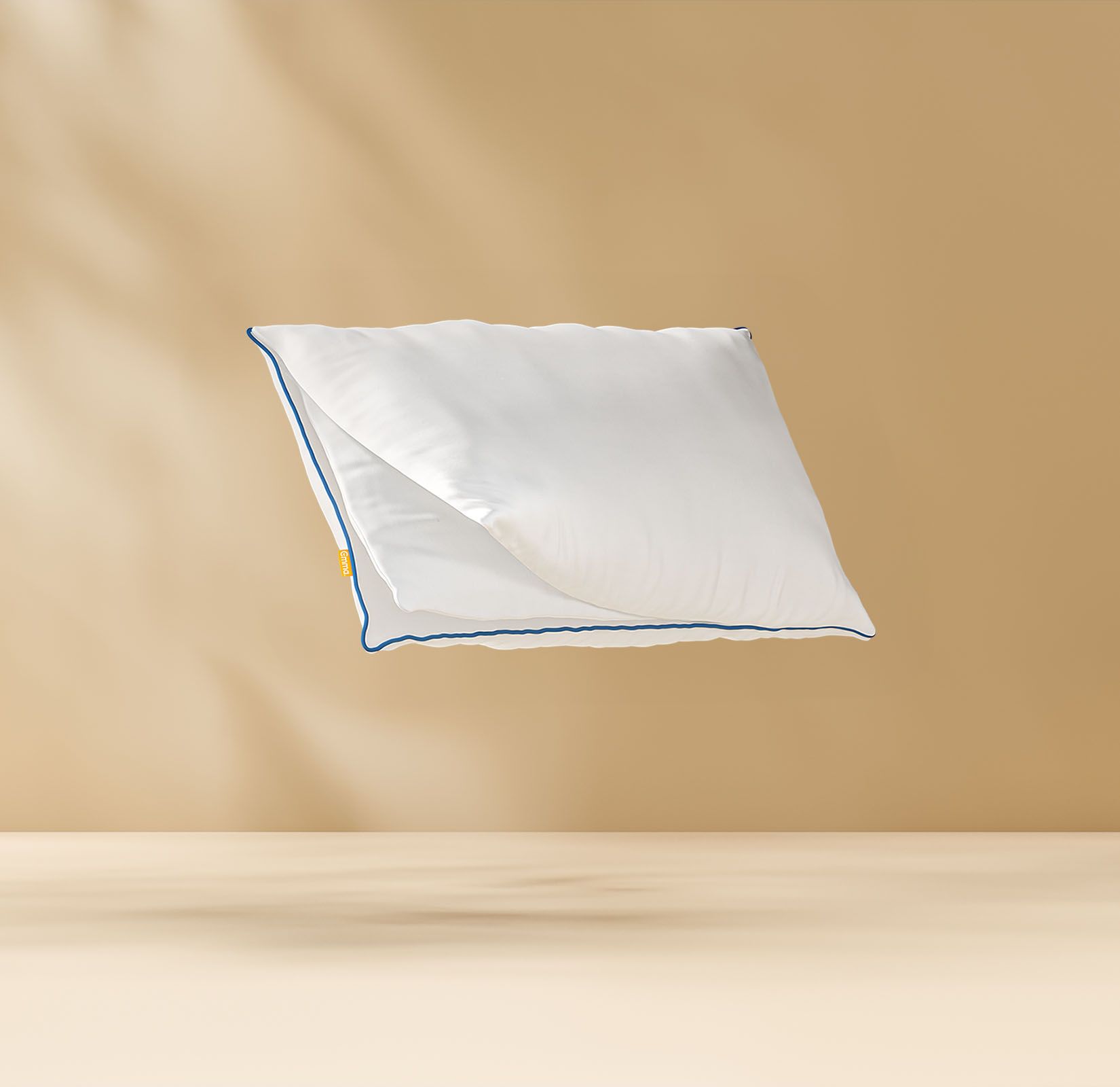 Floating pillow showing its inside foam layers with an Emma logo. Light bronze background.