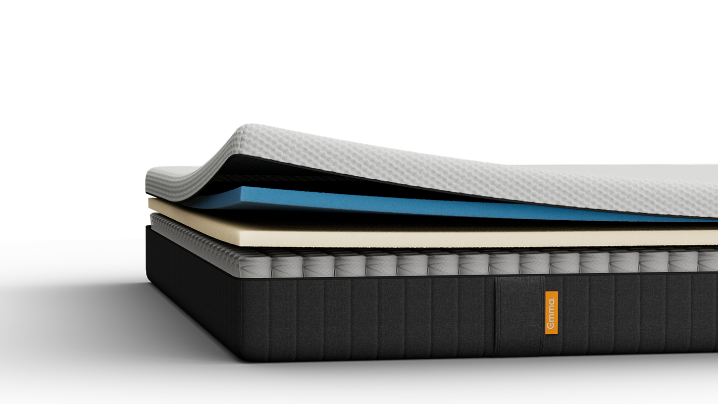 Lit tapissé gris avec matelas blanc, dans une chambre.