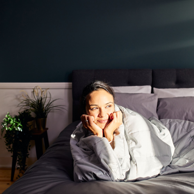 A girl covered in an Emma Hug Weighted Blanket