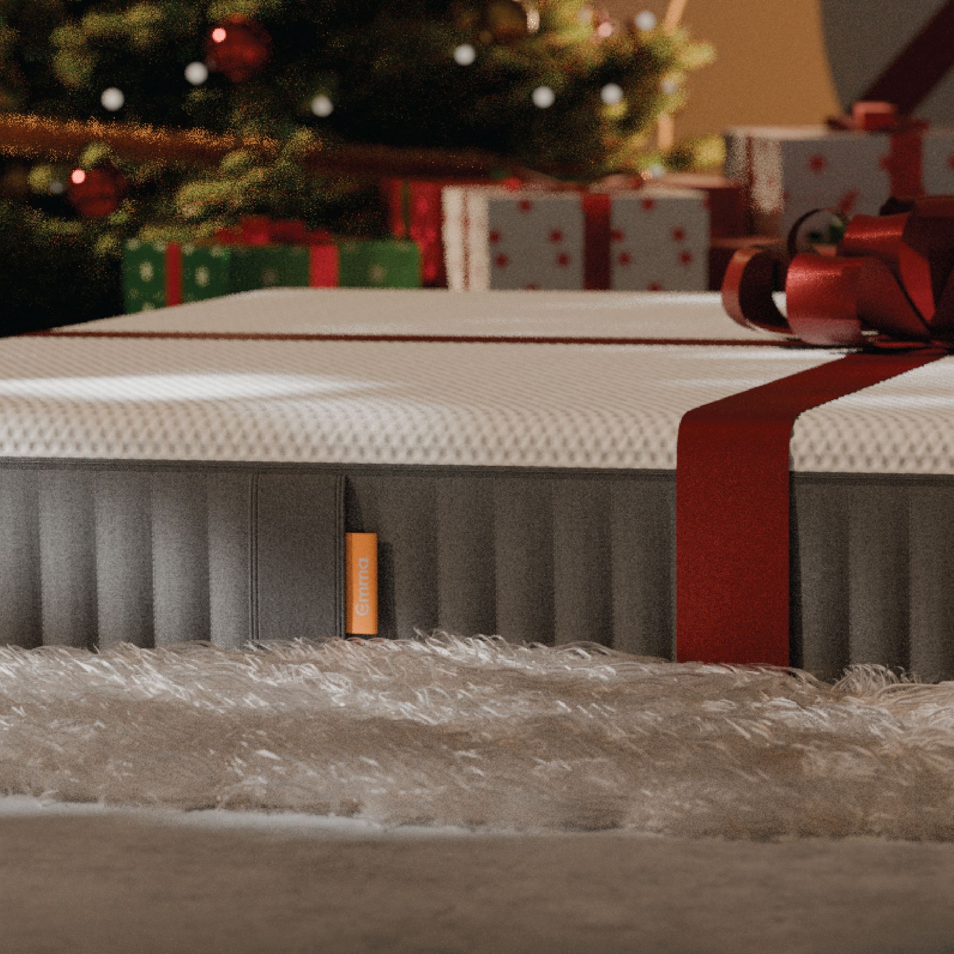 regalos debajo de un arbol de navidad y un colchón emma con un lazo rojo