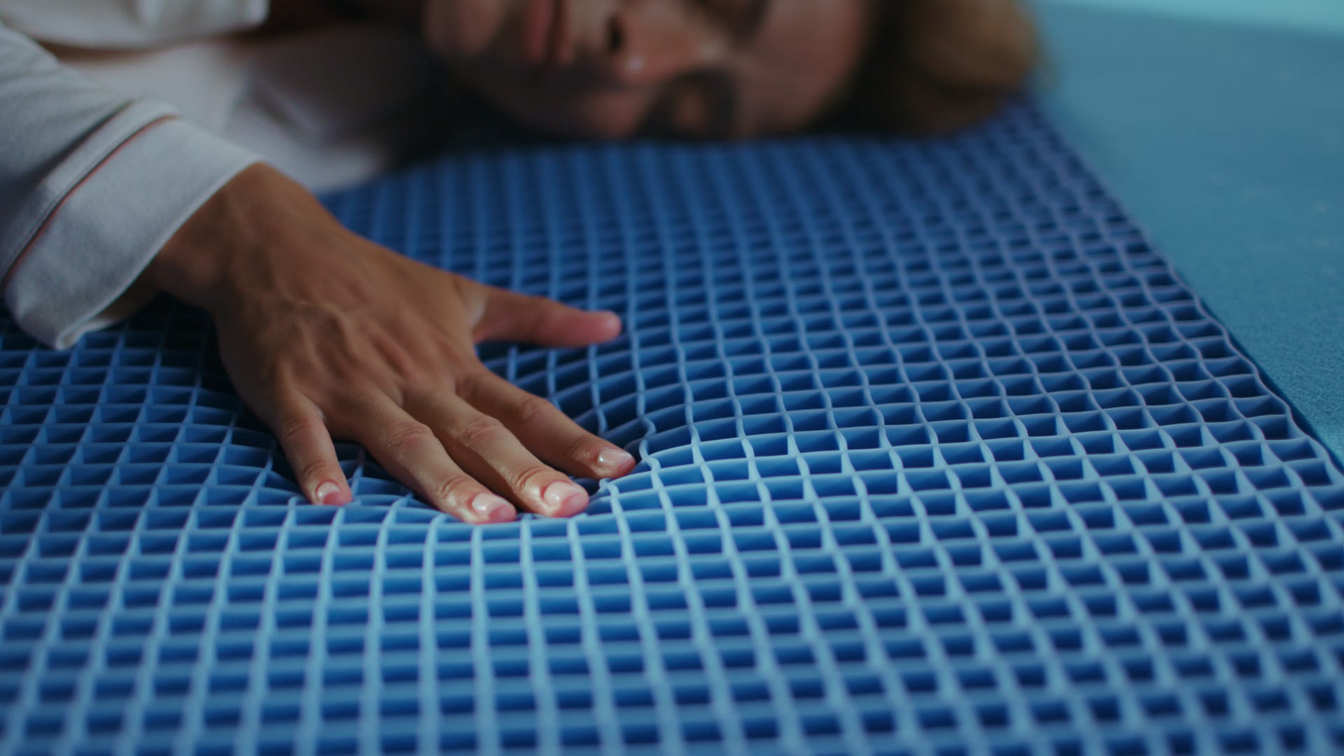 Mano che preme su superficie blu a griglia