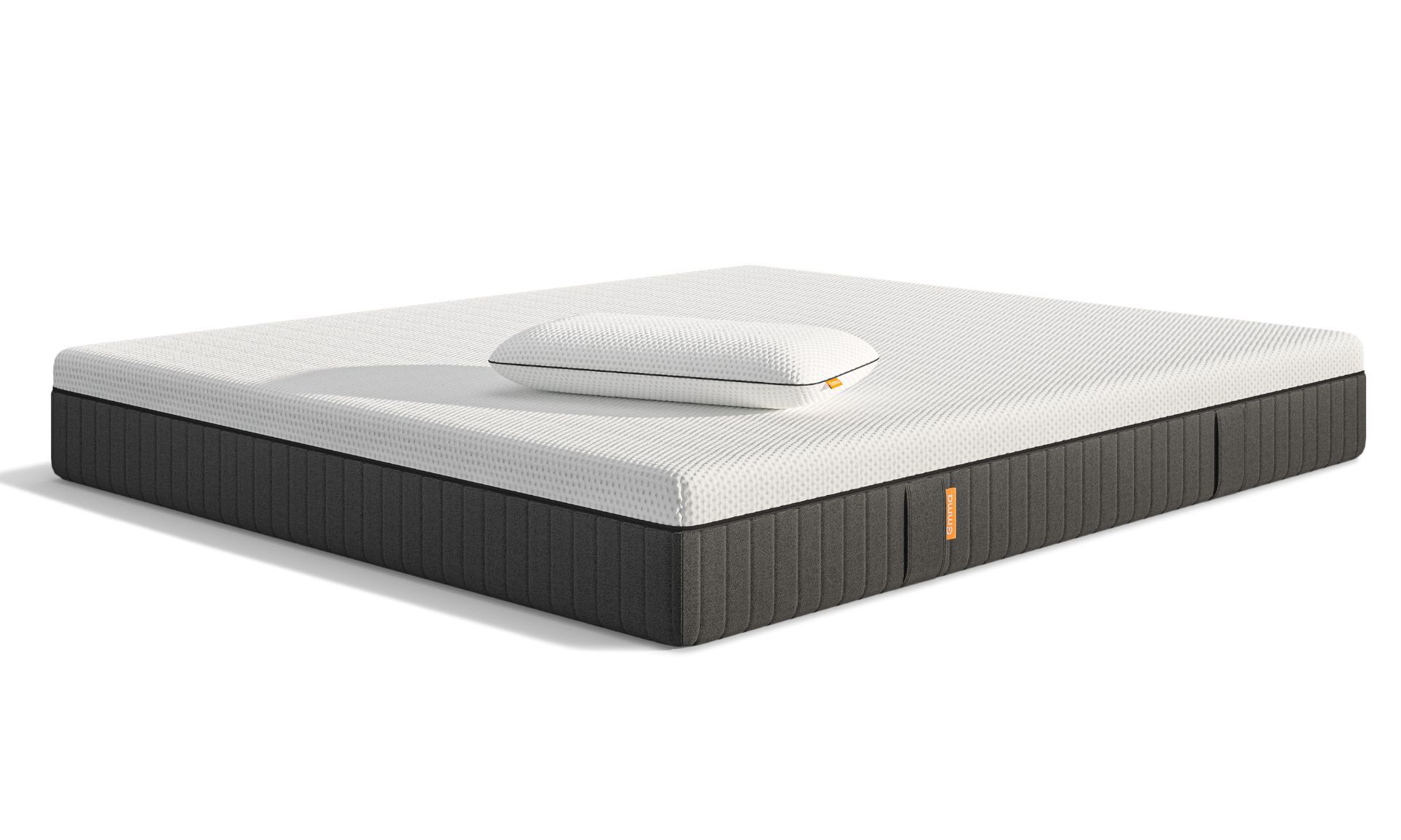 Materasso con superficie bianca, lati grigi e un cuscino bianco sopra.