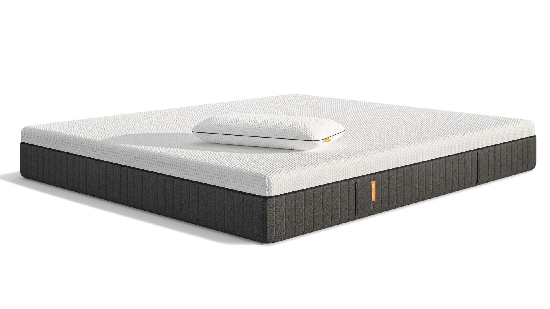 Materasso con superficie bianca, lati grigi e un cuscino bianco sopra.