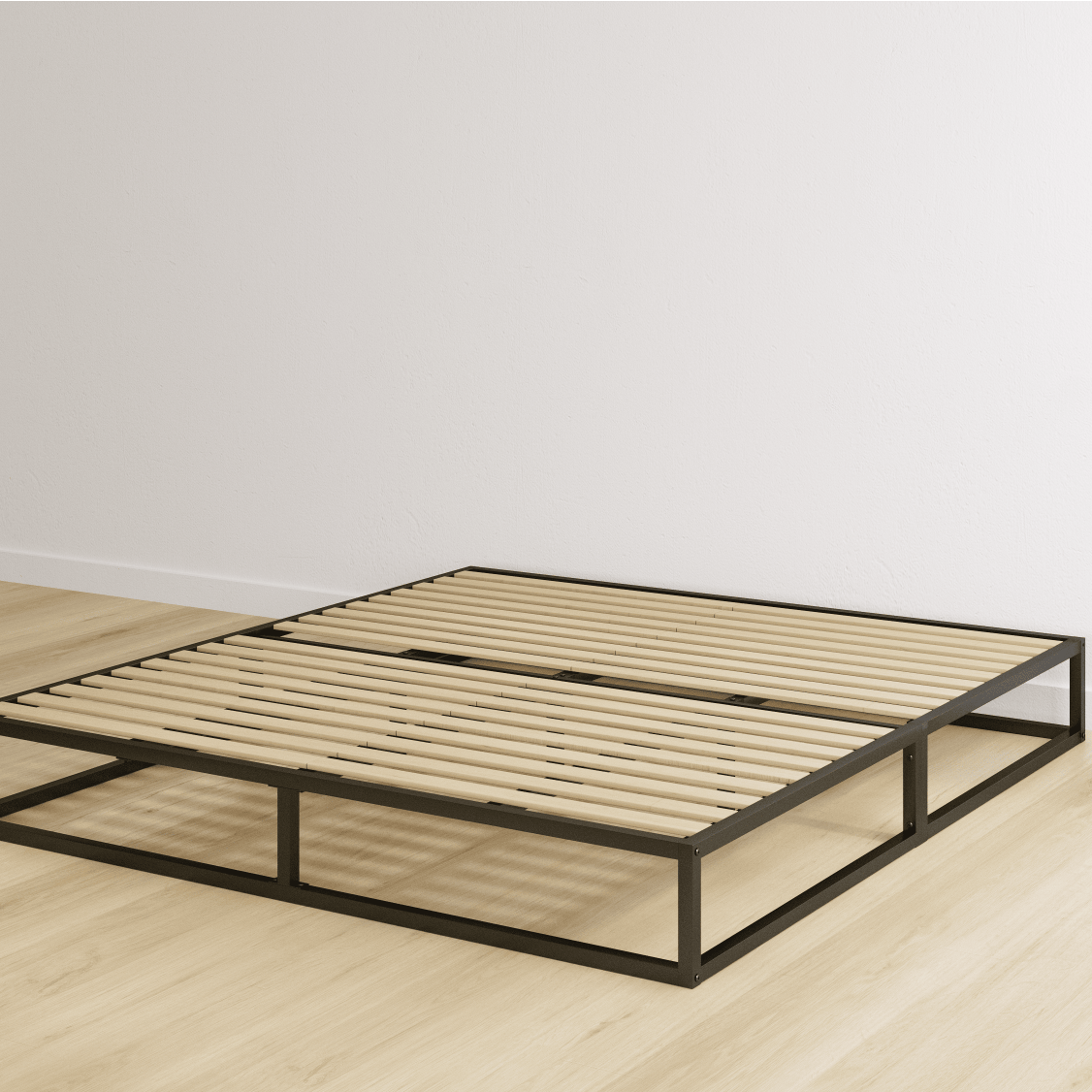Double bed with metal frame a metal headboard with pillows and wooden slats on a light wooden floor in an empty room.