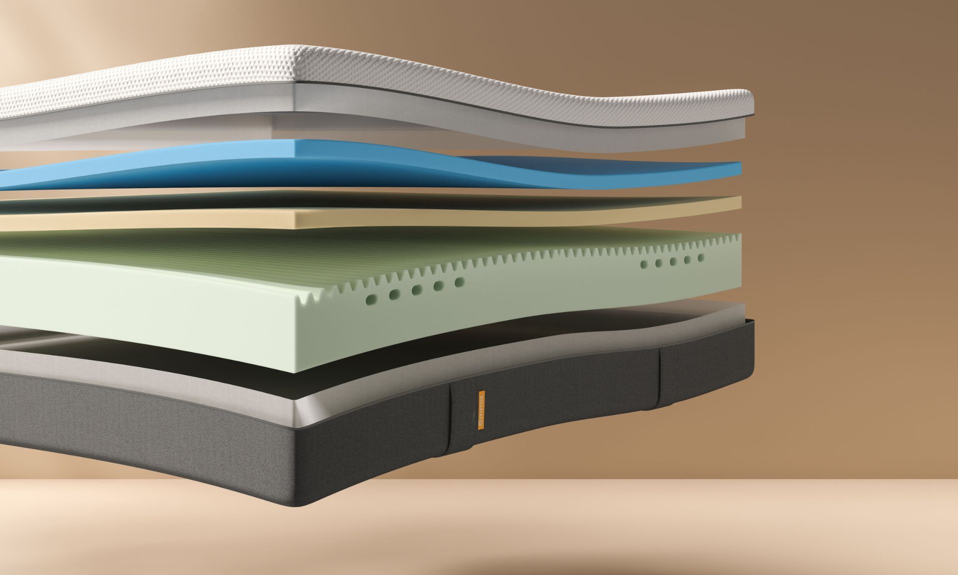 Sezione trasversale di un materasso multistrato con strati bianco, blu, beige, verde traforato, grigio e grigio scuro.