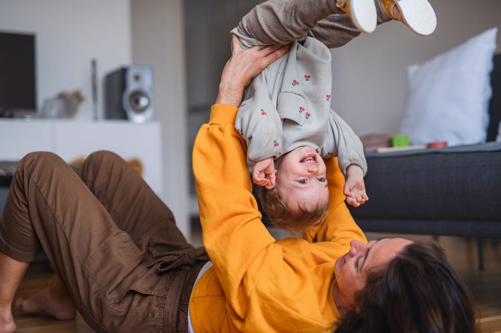 Madre levantando a su hijo en el aire y sonriendo