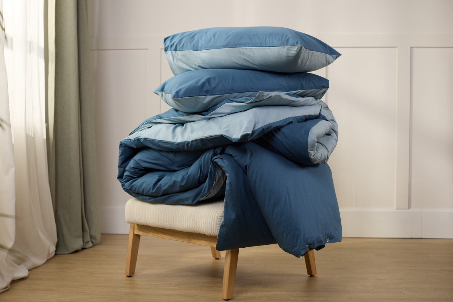 Kussens en dekbed met bijpassende hoezen op een houten stoel.