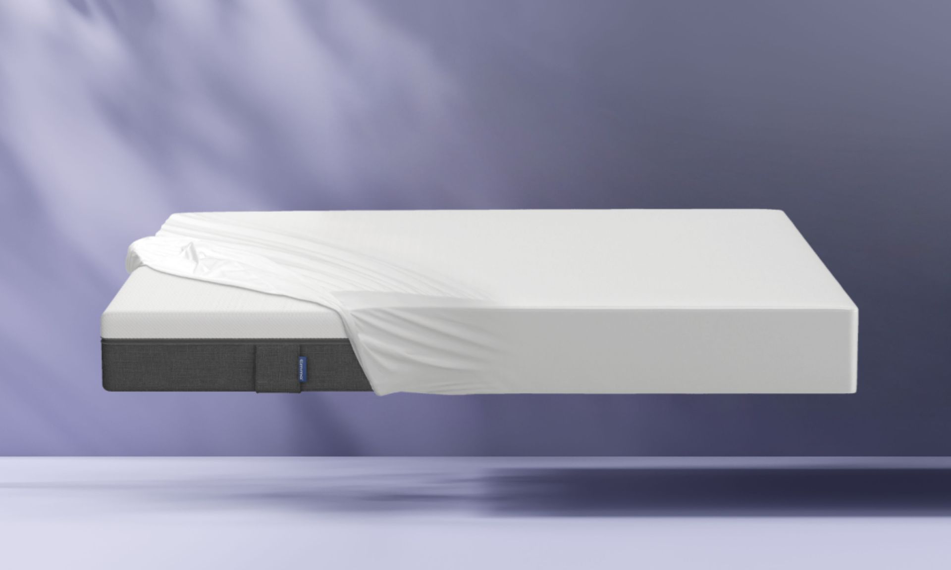 colchon emma con sabana bajera blanca sobre fondo morado