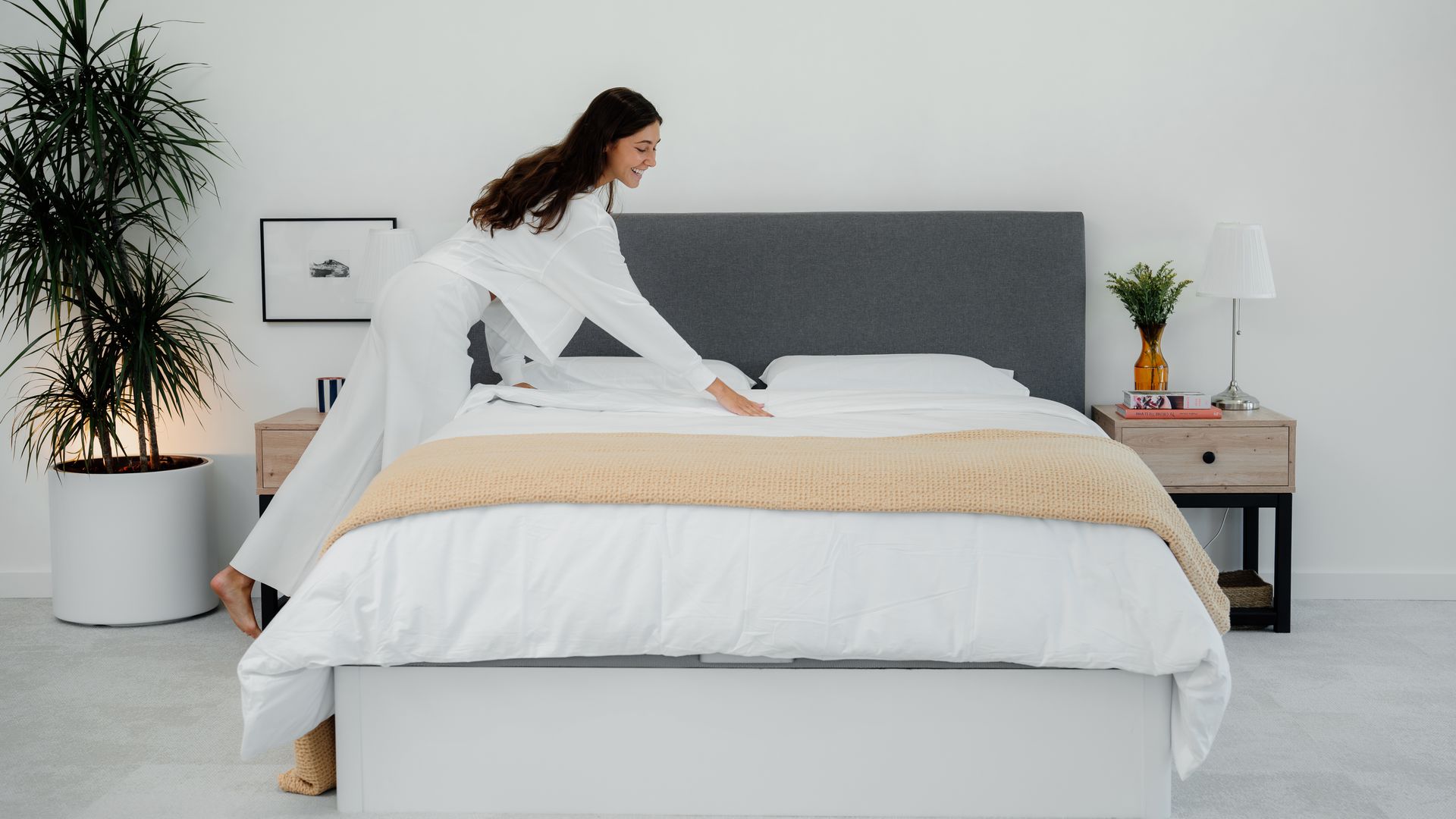 Mujer sonriendo y pasando la mano por el canapé abatible.