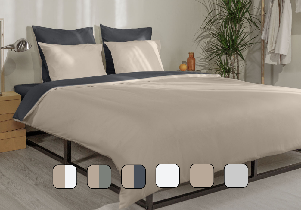 Chambre décorée avec lit, housse de couette et oreillers.