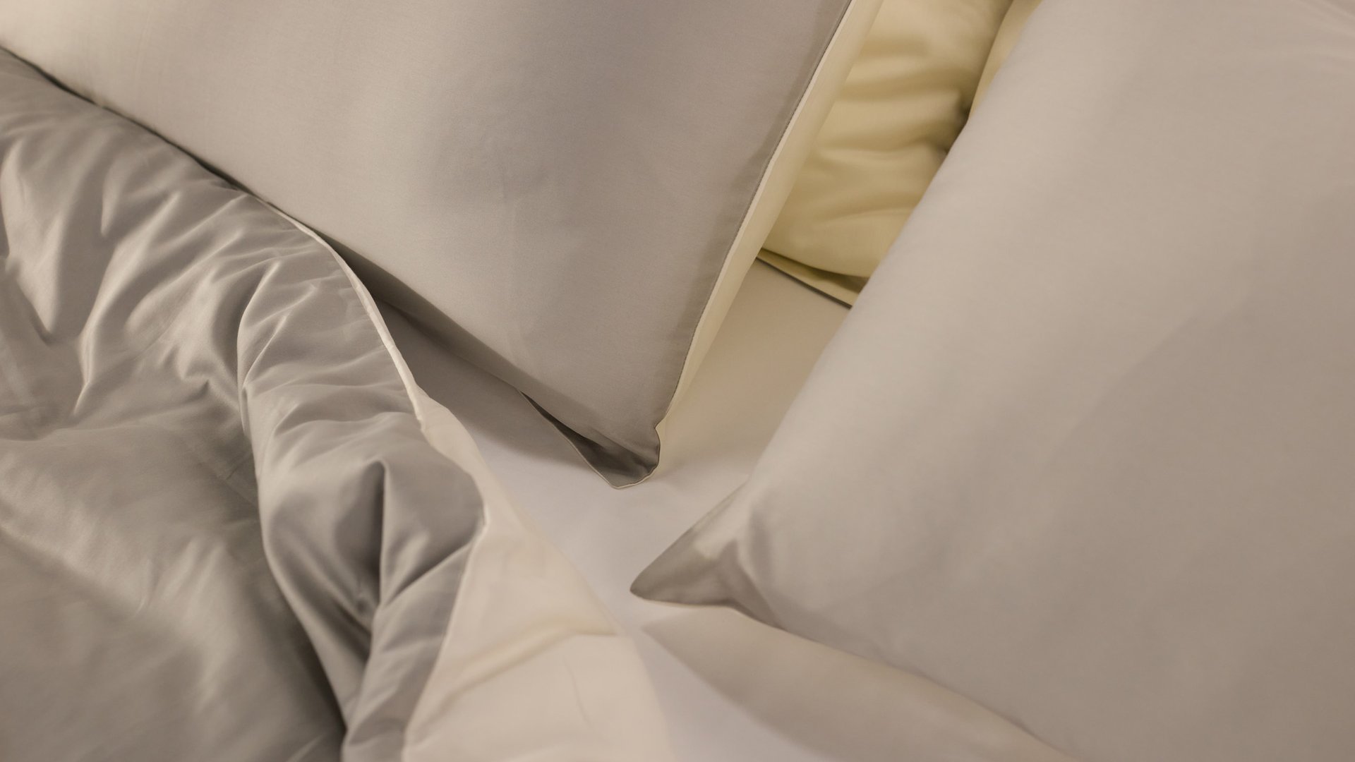 Bett mit weißer Bettdecke und Kissen.