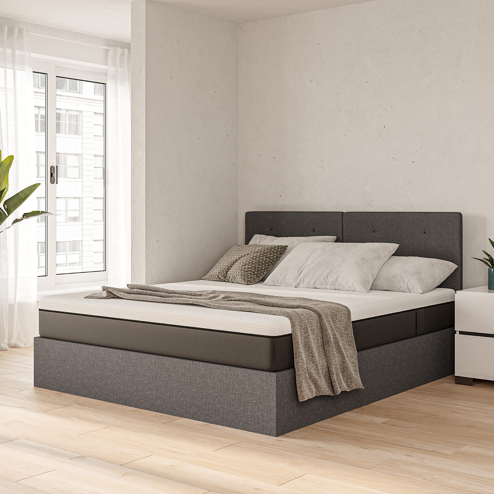 A side view of a bedroom with an Emma Ottoman Storage bed, pillows and bedding.