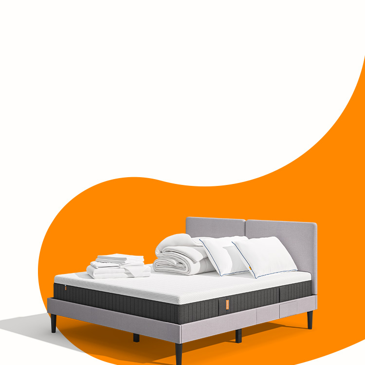 Lit moderne avec tête de lit grise et pieds noirs, recouvert de draps blancs. Deux oreillers blancs et une pile de linge plié sont posés sur le matelas. Arrière-plan beige avec une forme orange abstraite.