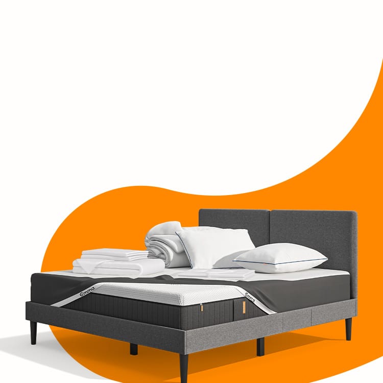 Lit moderne avec tête de lit grise et pieds noirs, recouvert de draps blancs. Deux oreillers blancs et une pile de linge plié sont posés sur le matelas. Arrière-plan beige avec une forme orange abstraite.