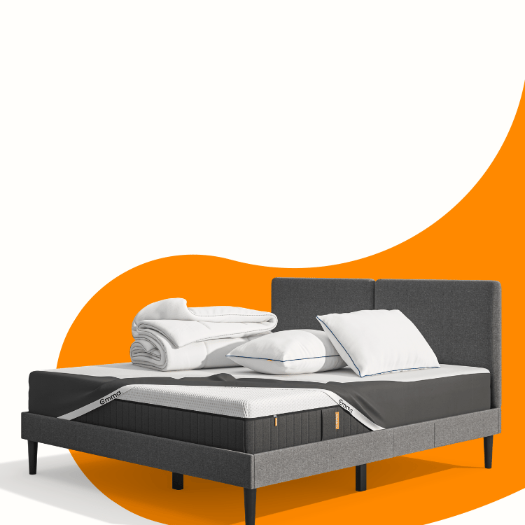 Lit moderne avec tête de lit grise et pieds noirs, recouvert de draps blancs. Deux oreillers blancs et une pile de linge plié sont posés sur le matelas. Arrière-plan beige avec une forme orange abstraite.