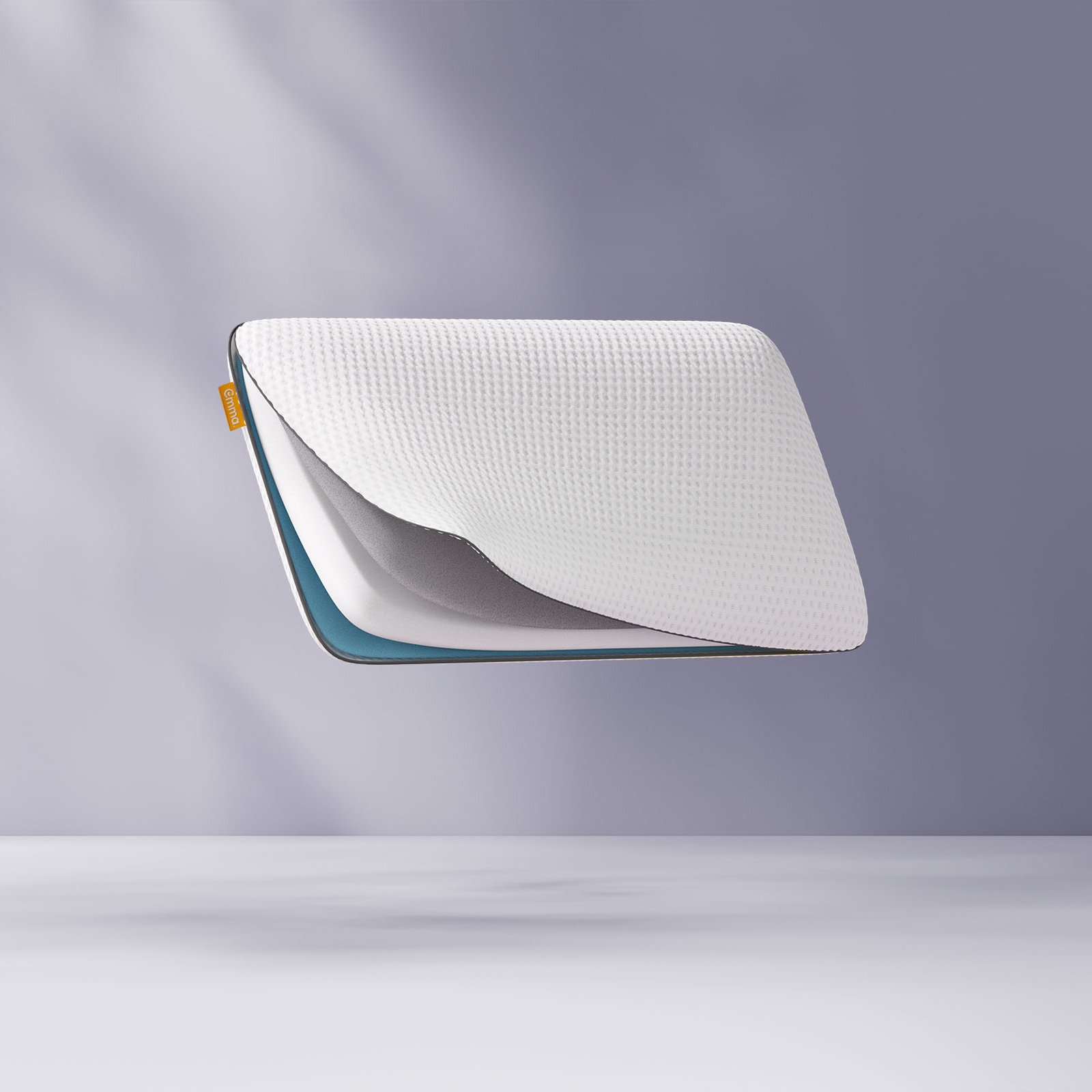 Oreiller flottant avec une grille en forme de nid d’abeille bleue, partiellement ouvert pour révéler le tissu intérieur, sur un fond violet clair.