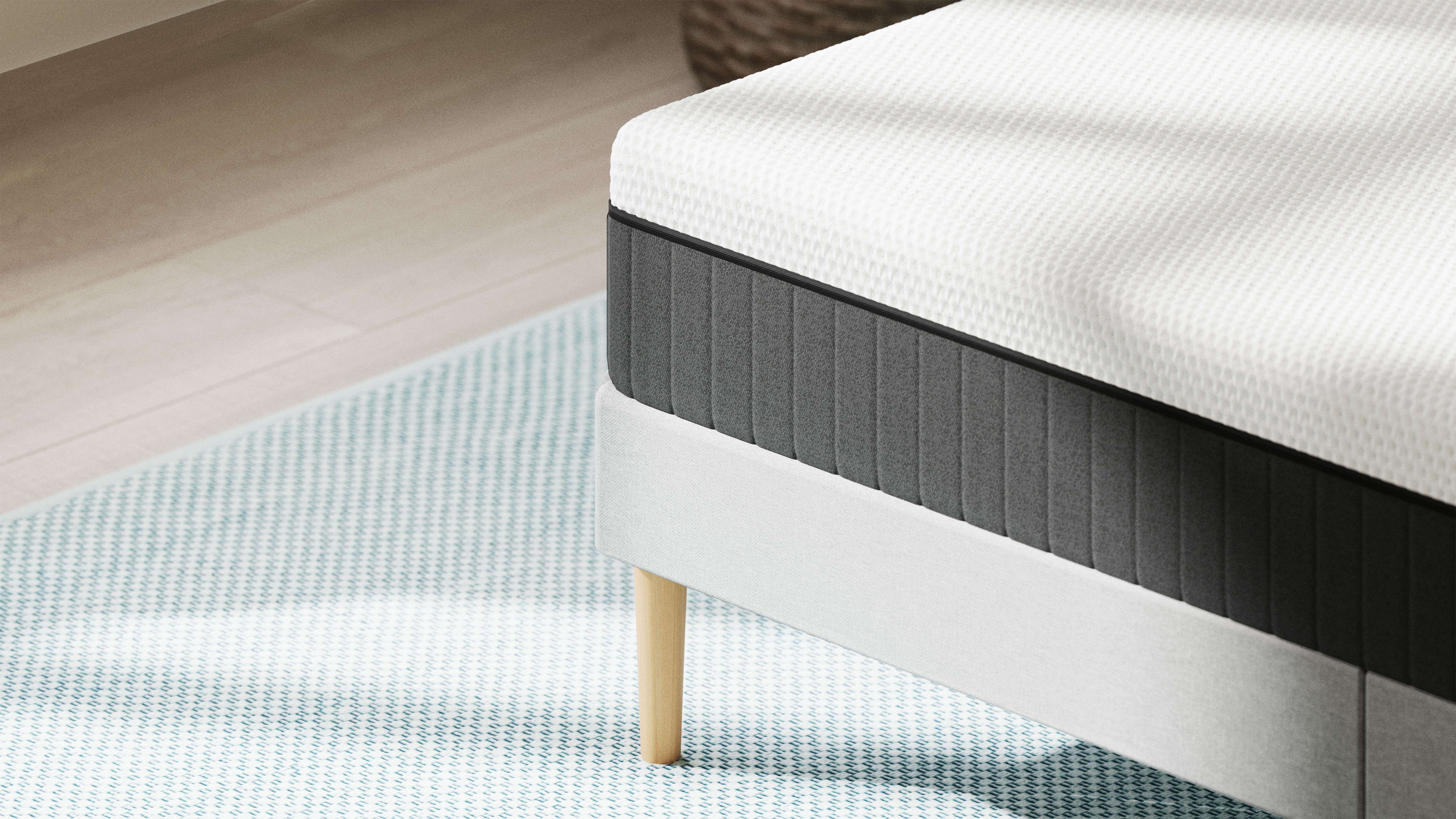 Primo piano di un letto con materasso bianco e base grigia su tappeto azzurro