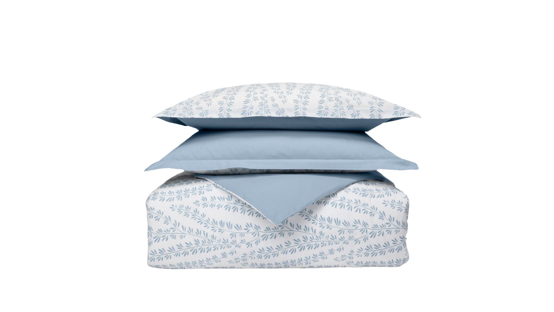Set di biancheria impilato con cuscini e piumone a motivo foglia blu su sfondo bianco e un cuscino azzurro.