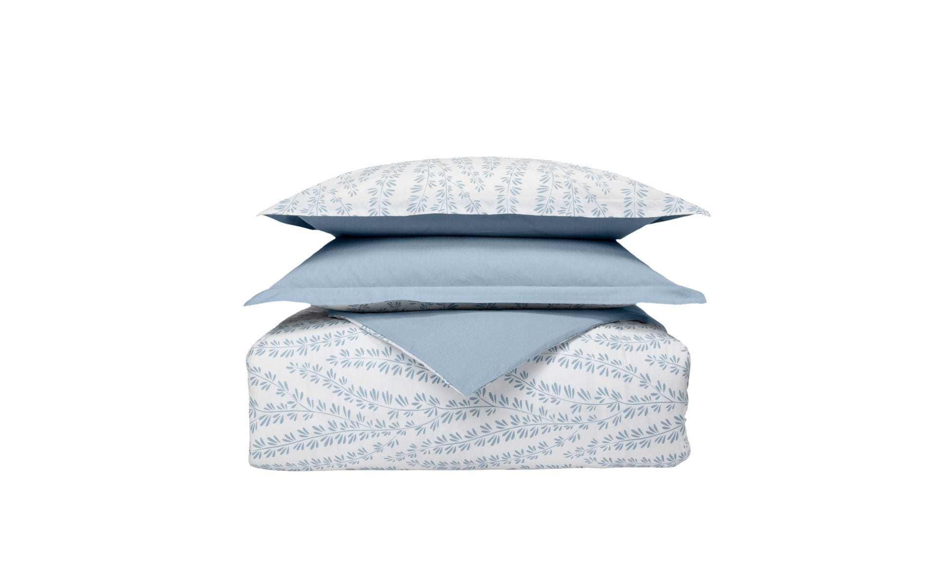 Set di biancheria impilato con cuscini e piumone a motivo foglia blu su sfondo bianco e un cuscino azzurro.