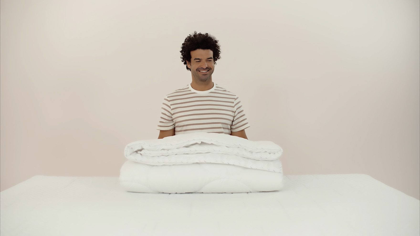 chico sonriendo con un edredon delante encima de una mesa