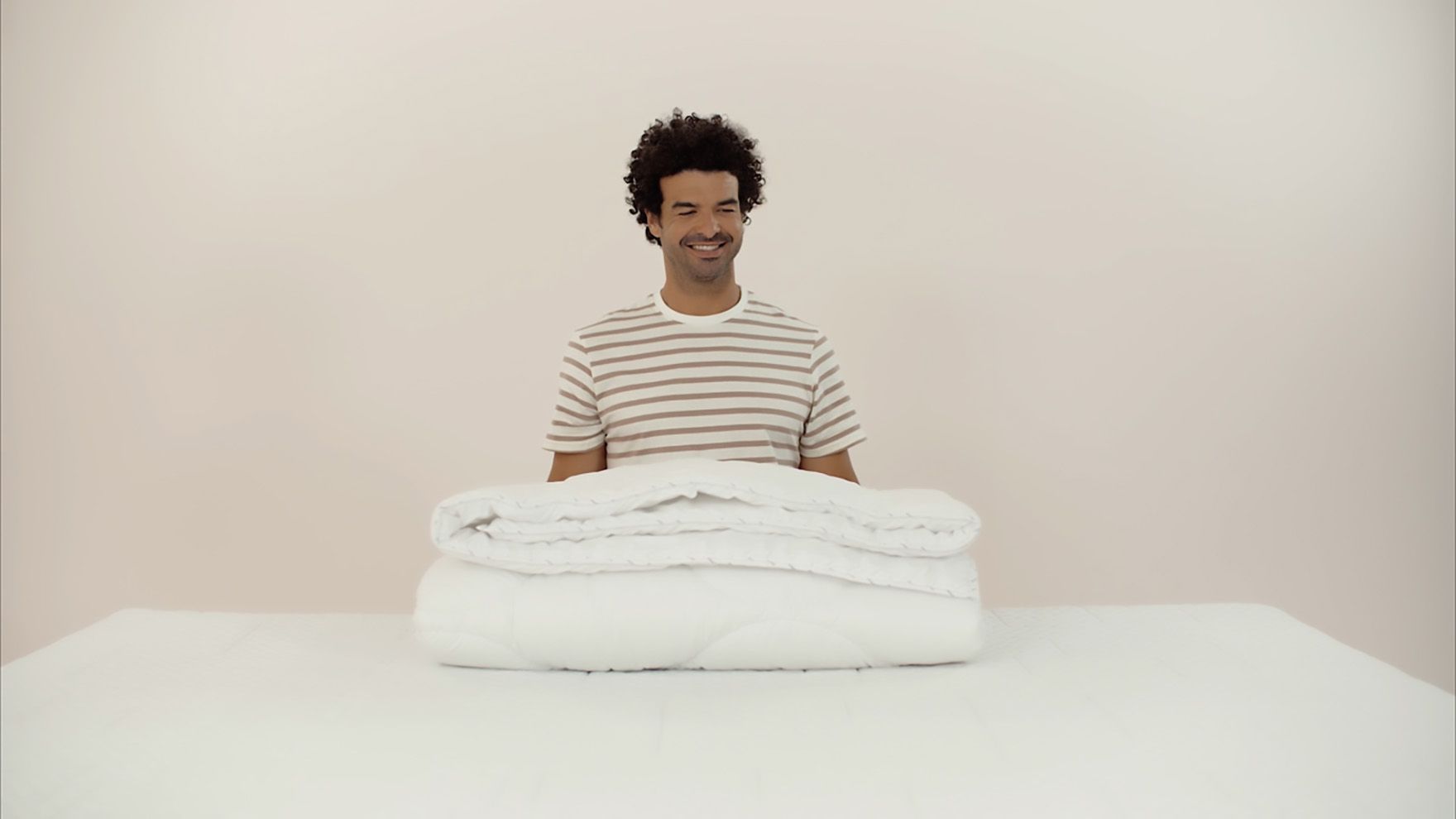 chico sonriendo con un edredon delante encima de una mesa