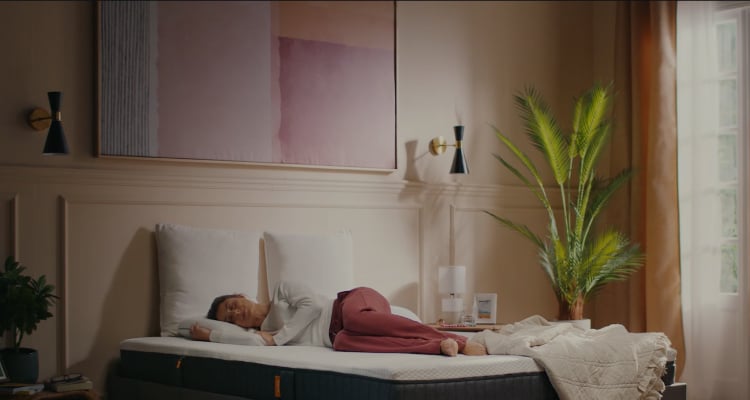 A woman laying on an Emma Mattress.