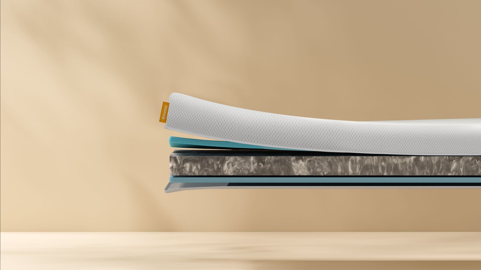 Doorsnede van de Emma Baby & Kindermatras met meerdere lagen, waaronder een witte ademende hoes, blauwe schuimlaag en kern van stevig materiaal, tegen een beige achtergrond.