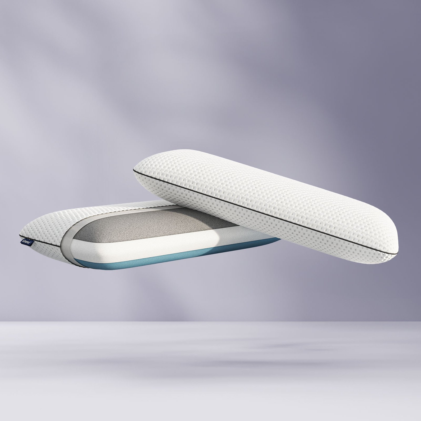 Deux Oreillers Original Premium flottants, dont un en coupe montrant ses trois couches ergonomiques.