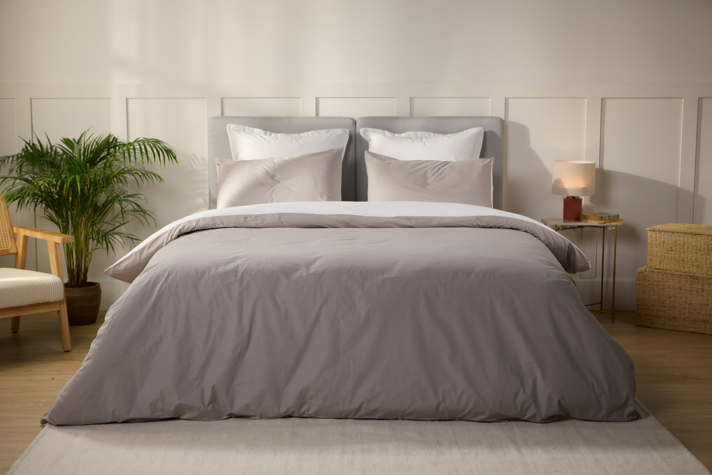 Vue de face d’une chambre décorée, avec un lit doté d’une couette colorée et de taies d’oreiller.