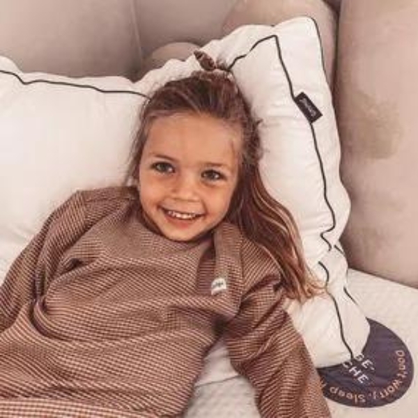 Kind ligt ontspannen op een Emma Wolkenkussen - een verstelbaar kussen dat zowel zacht als ondersteunend is.