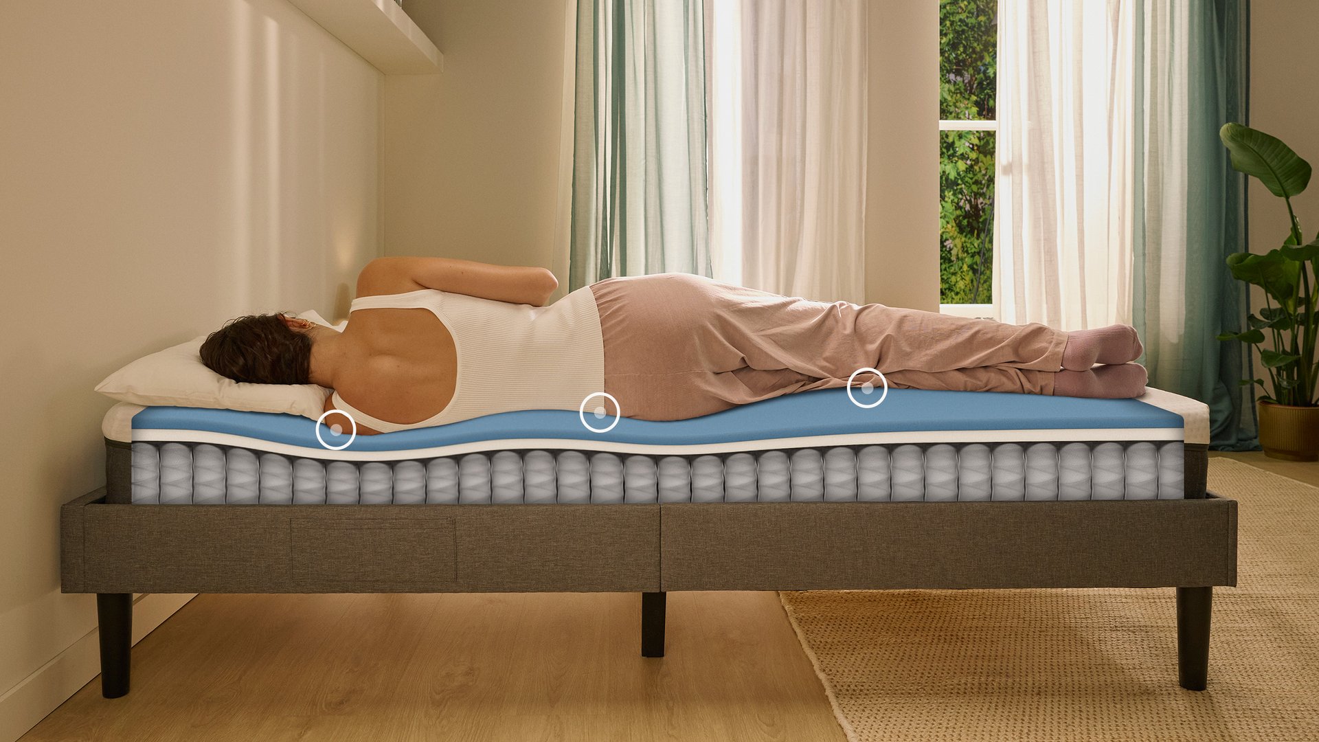 Personne allongée sur le côté sur un matelas hybride avec matelas en mousse, montrant l’alignement ergonomique de la colonne vertébrale.