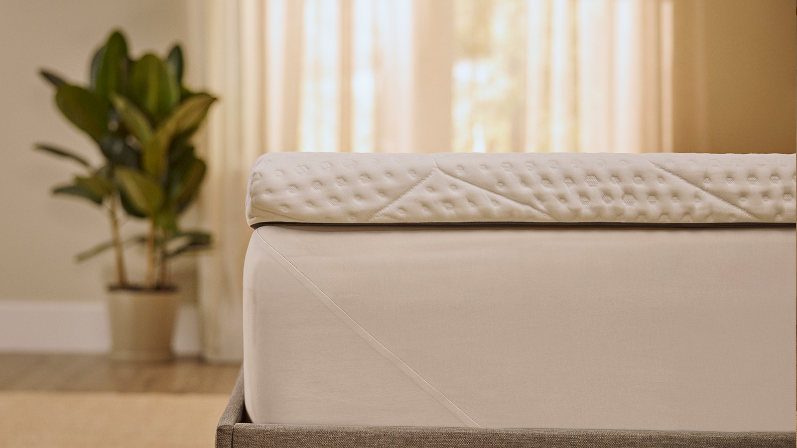 Emma-topper die strak om de hoek van het matras zit, zodat je een stevige pasvorm en naadloze aansluiting ziet.