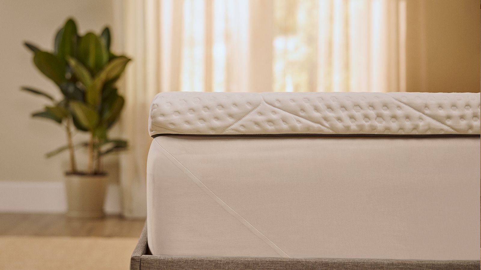 Emma-topper die strak om de hoek van het matras zit, zodat je een stevige pasvorm en naadloze aansluiting ziet.