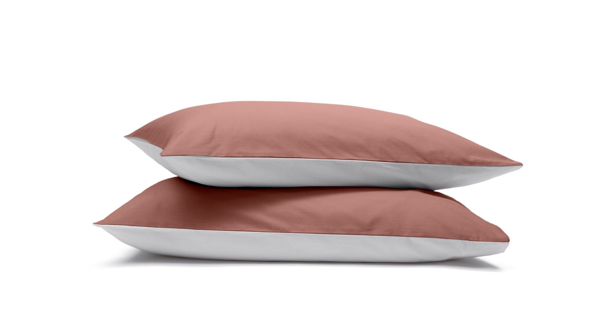 Due federe terracotta e grigie impilate su sfondo bianco.