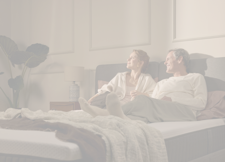 A couple laying on top of an Emma Mattress.