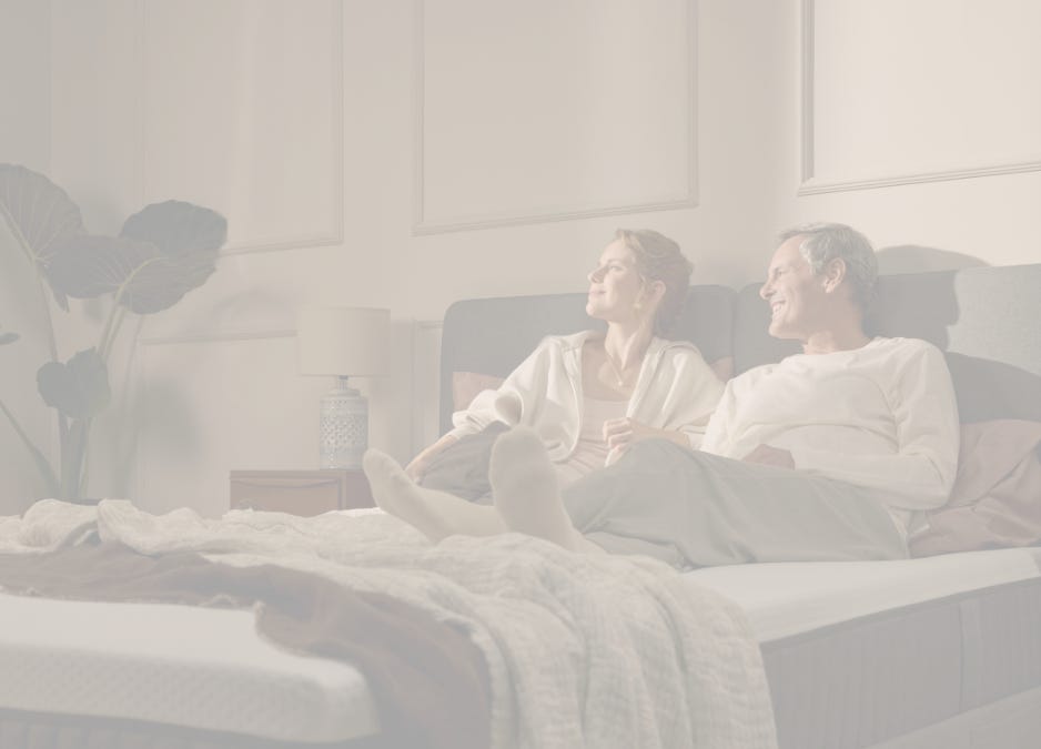 A couple laying on top of an Emma Mattress.