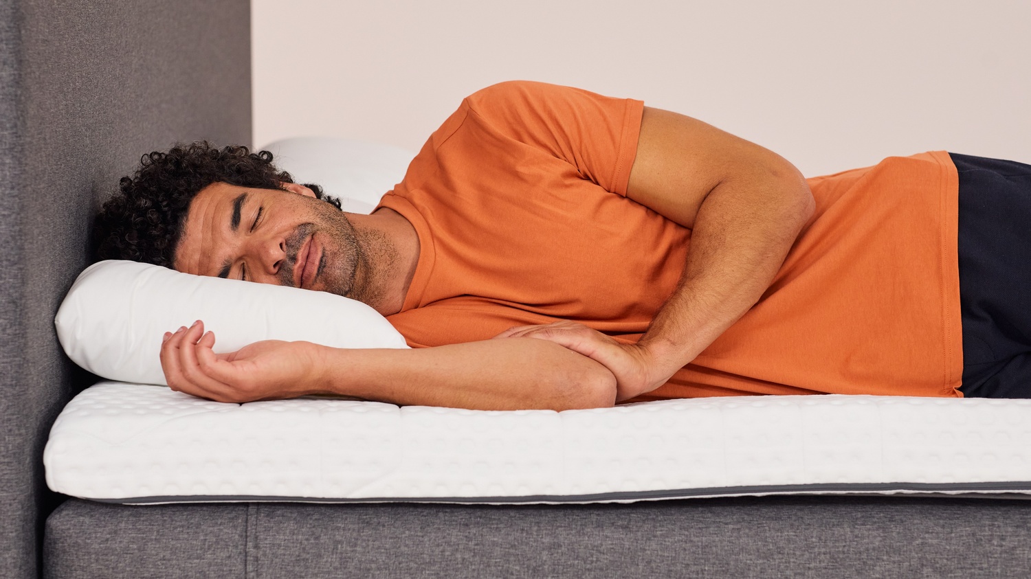 Man sleeping on side on Emma topper, showing pressure relief and body support.