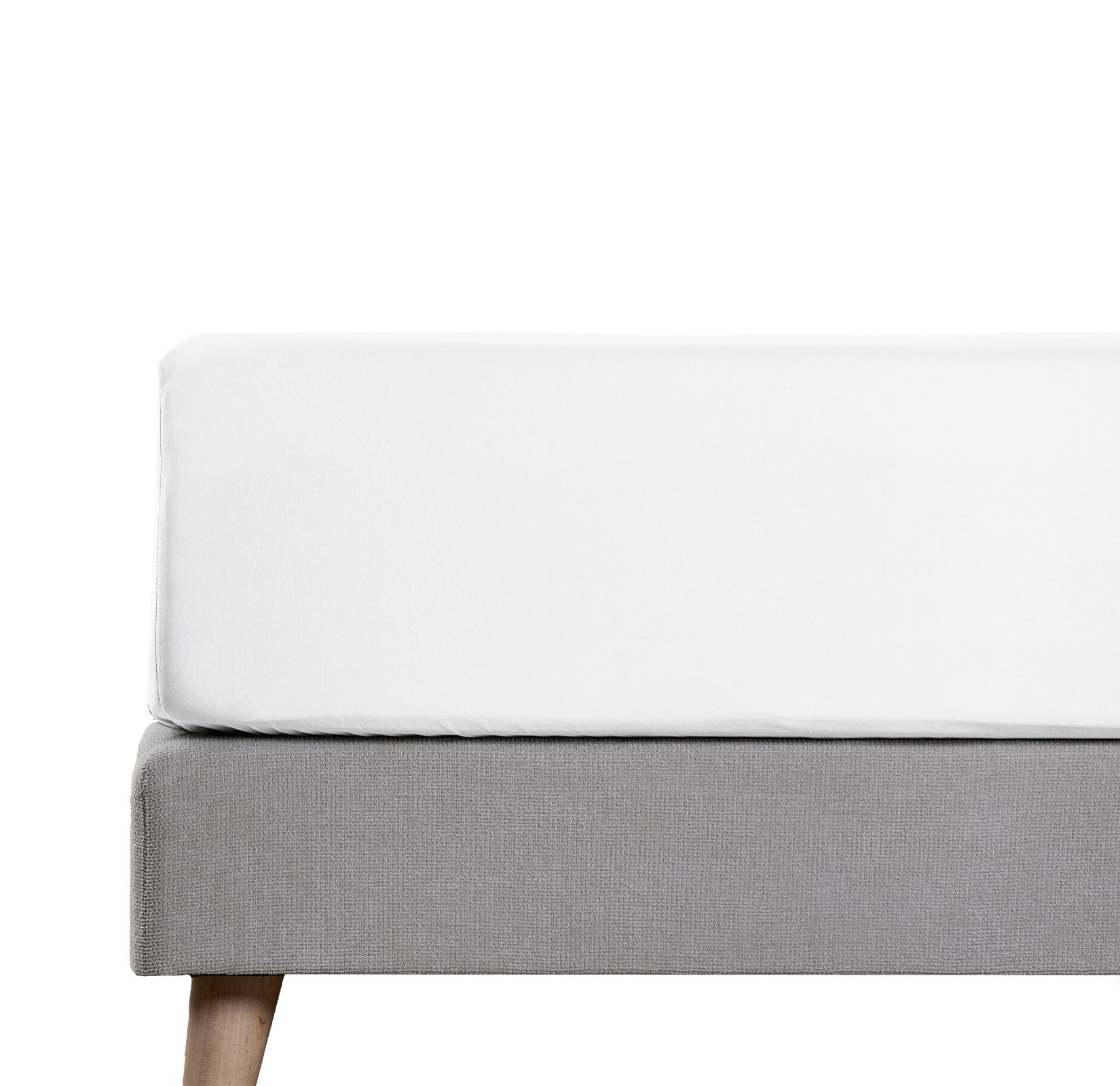 Angolo di materasso con lenzuolo bianco e gambe in legno.