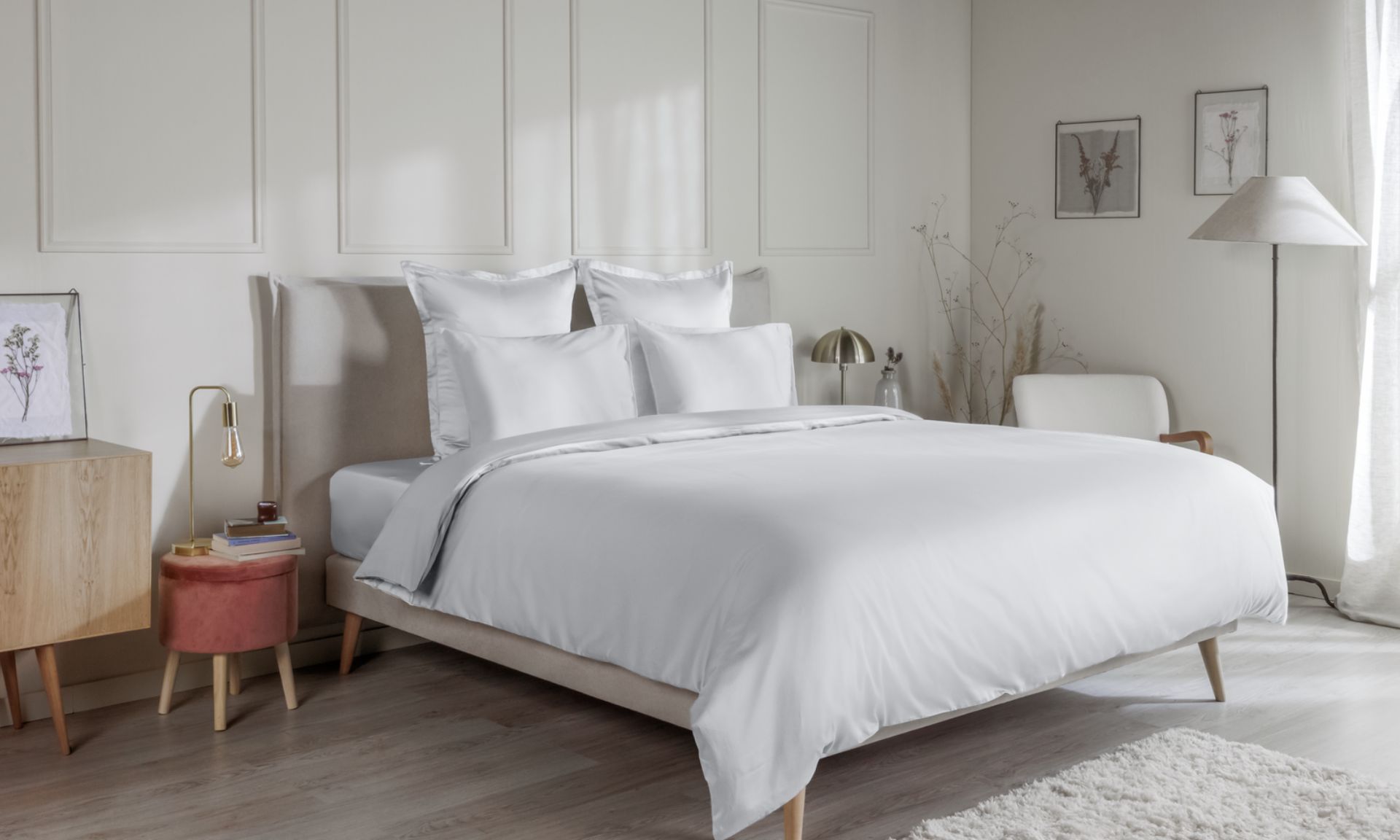 Letto con federe bianche, copripiumino coordinato e testiera in legno a doghe.