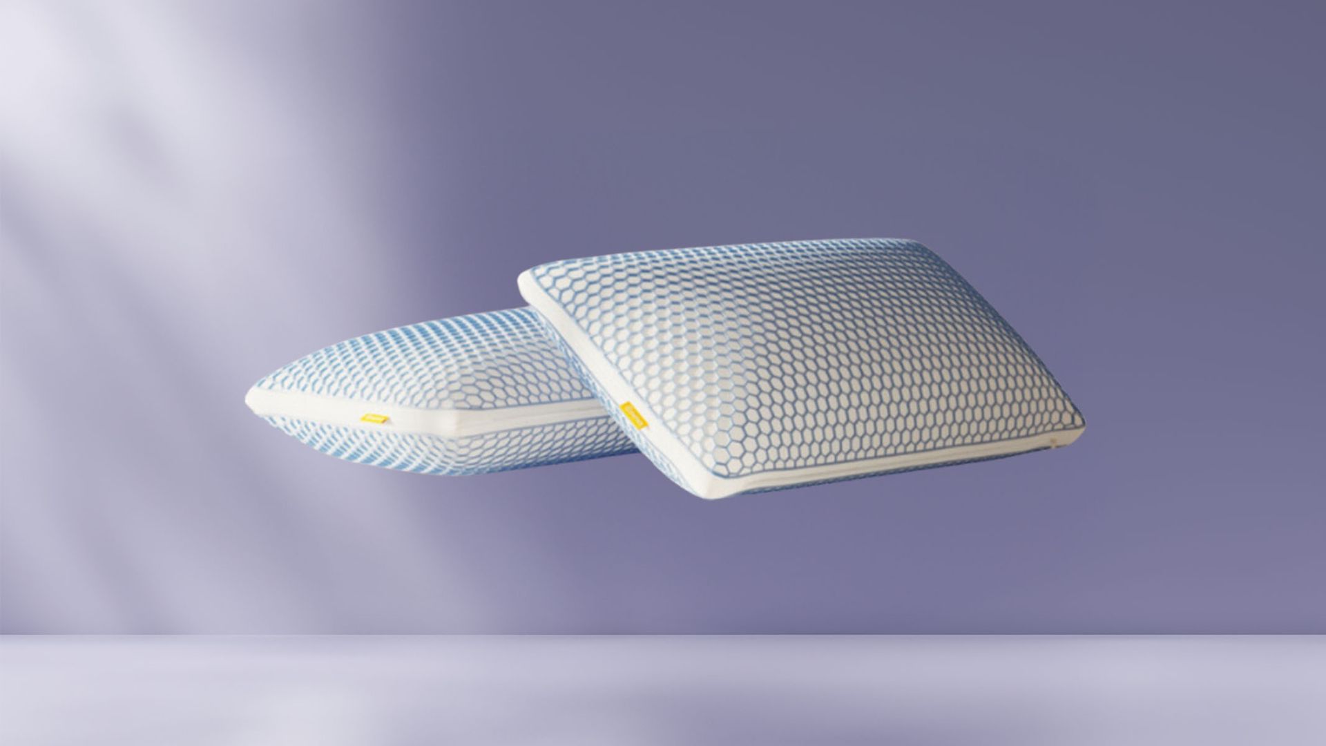 Duas almofadas Emma Zero Gravity empilhadas sobre fundo azul