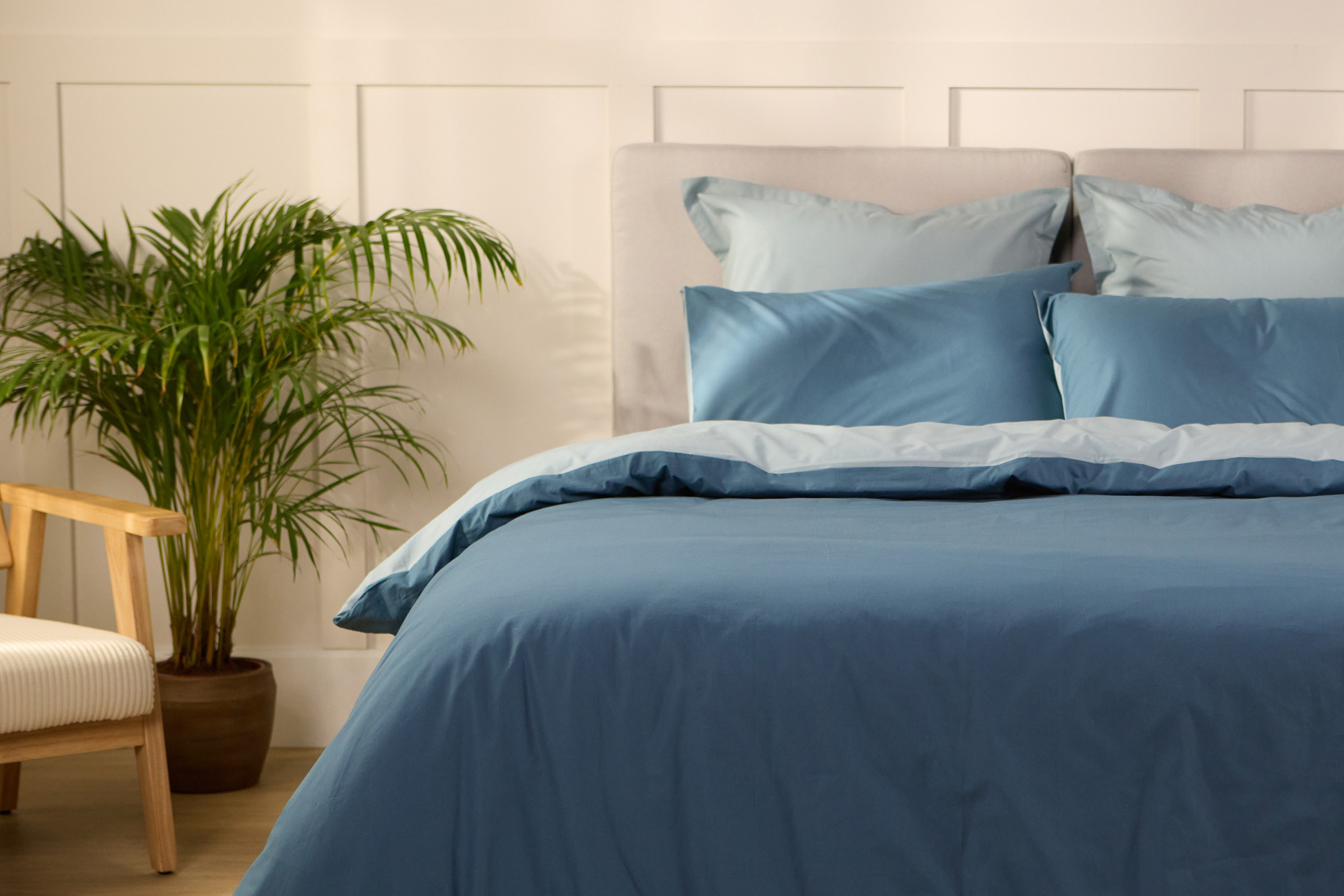 Vue de face d’une chambre décorée, avec un lit doté d’une couette colorée et de taies d’oreiller.