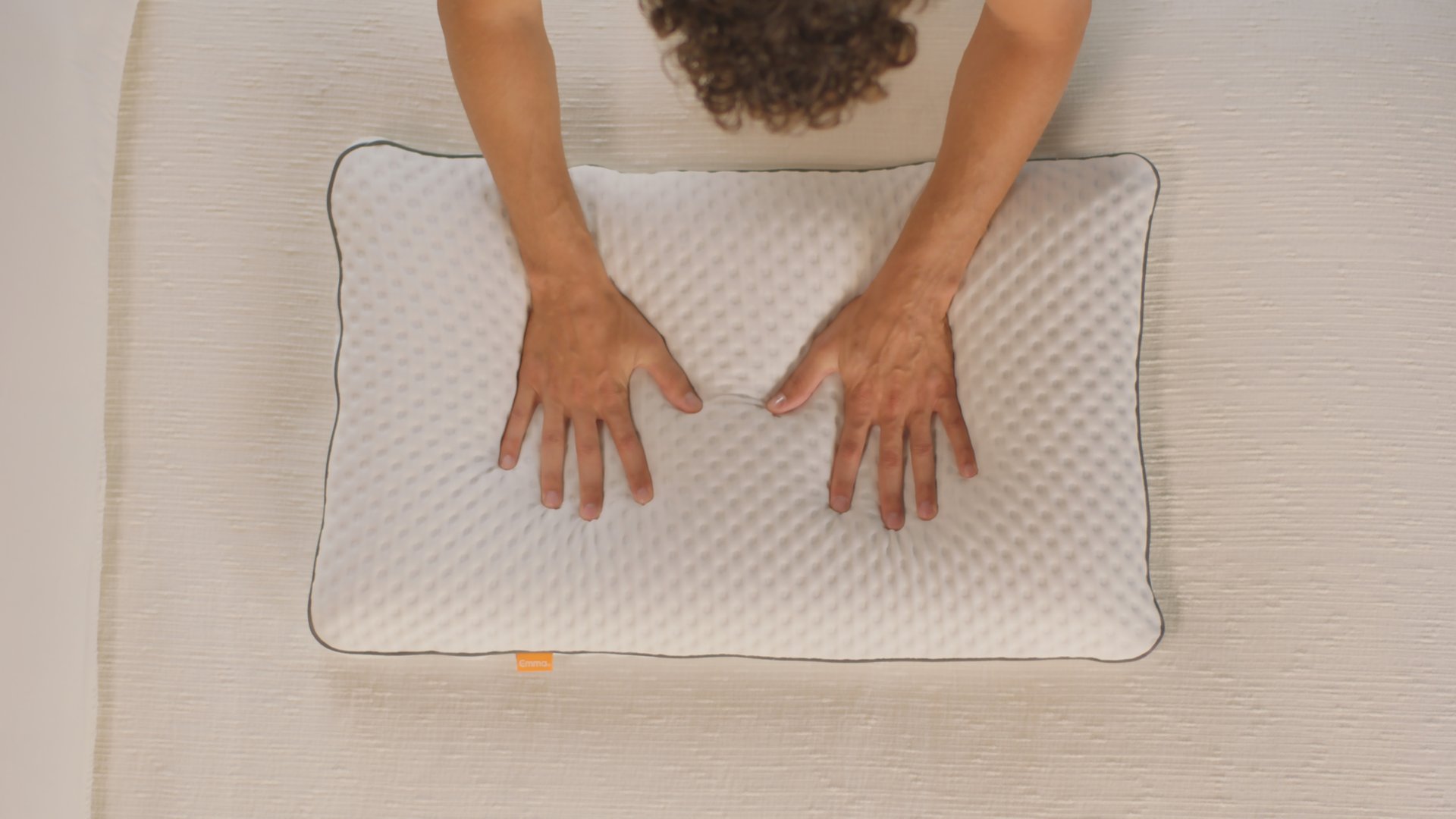 Persona hundiendo sus manos en la almohada viscoelástica premium
