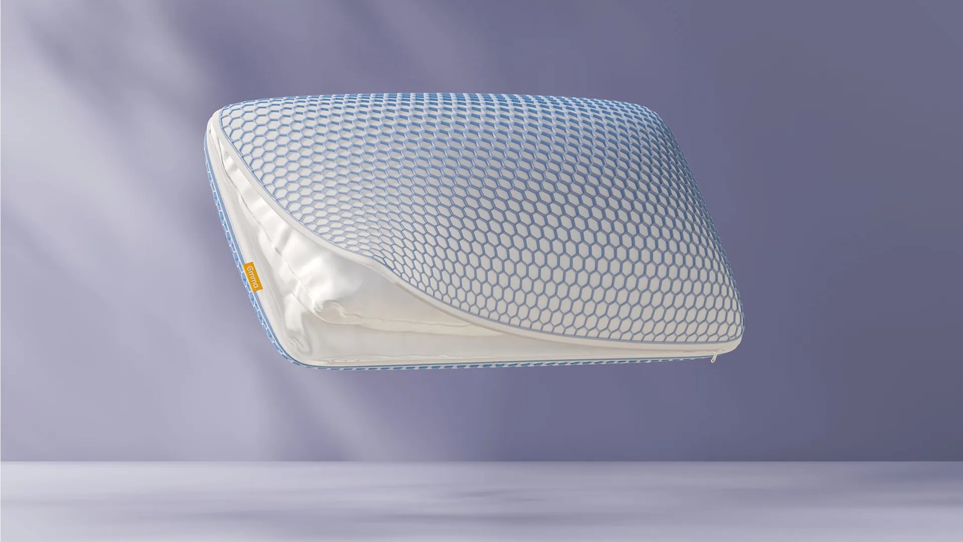 AirGrid® Comfort Kussen zwevend tegen paarse achtergrond, met zichtbare witte binnenvulling door half geopende rits en kenmerkende honingraatstructuur.