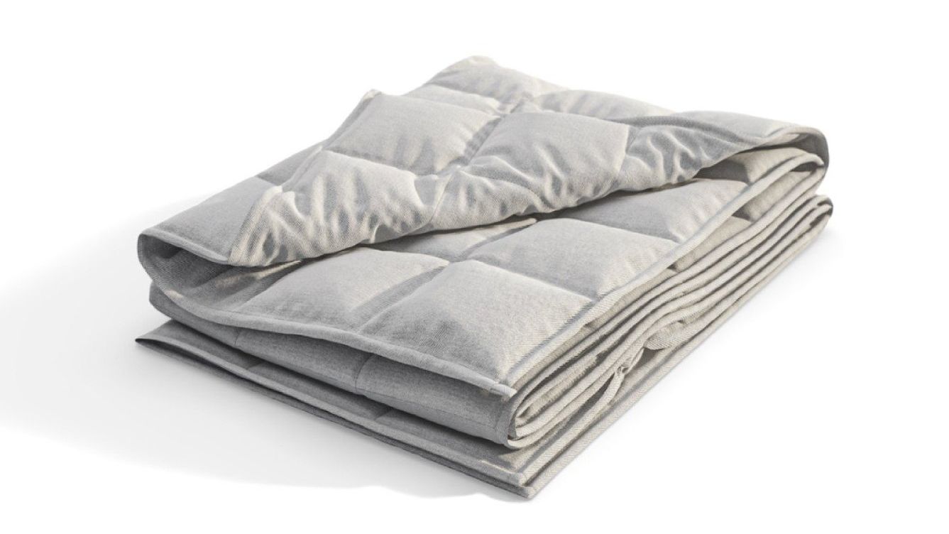 Netjes opgevouwen grijze Emma Verzwaringsdeken met gewatteerd vierkant patroon – straalt zachtheid, comfort en geborgenheid uit.